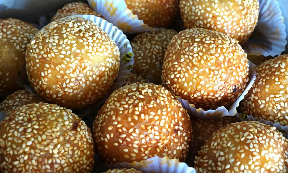Glutinous fried sesame balls fully coated in white sesame seeds lined in paper liners at 88Baobao, a Chinese restaurant in Lubbock.